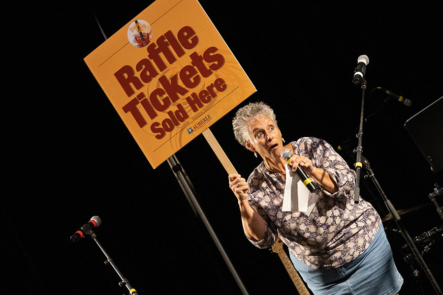 Woman holding raffle sign with microphone